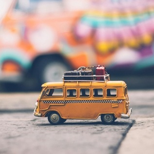 Mini travel van with luggage, symbol of fun holiday tour
