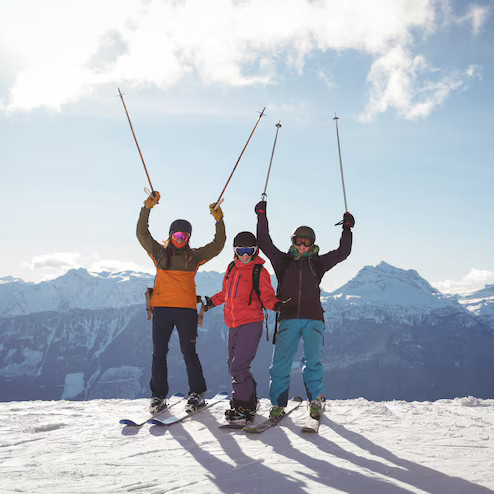 Skiers on snow peak – fun tourist adventure