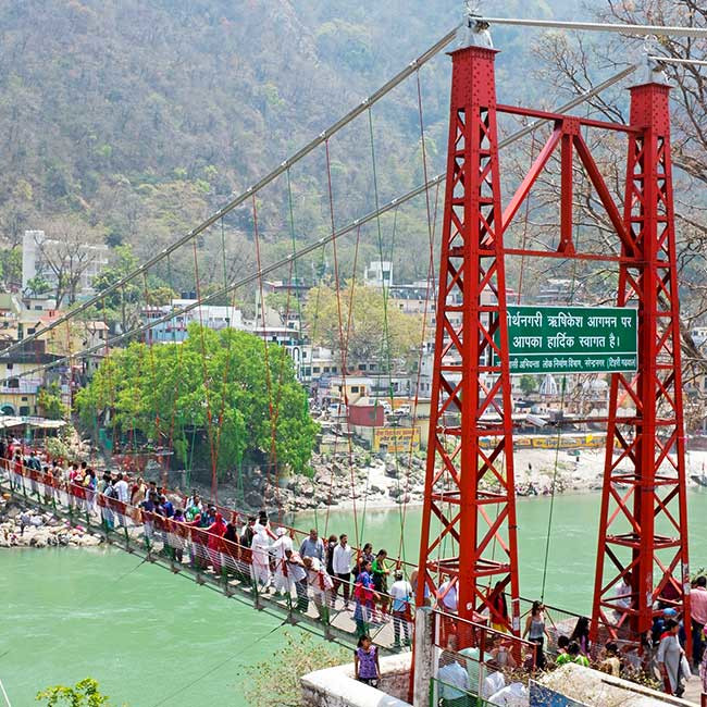 Tourists cross Lakshman Jhula bridge in Rishikesh